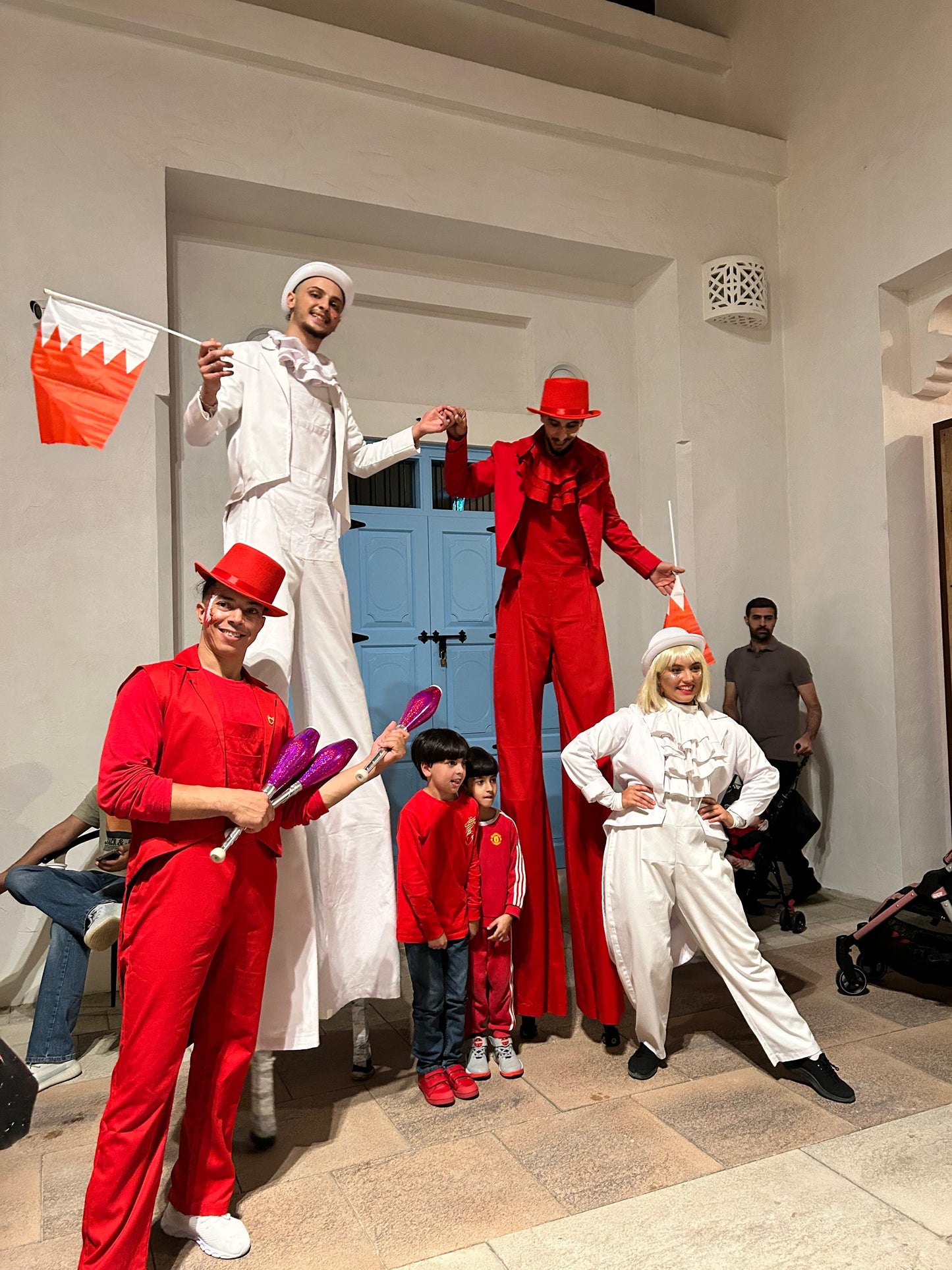 Red and white christmas parade with stilt walker