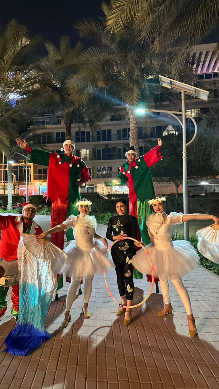 Red and white christmas parade with stilt walkers